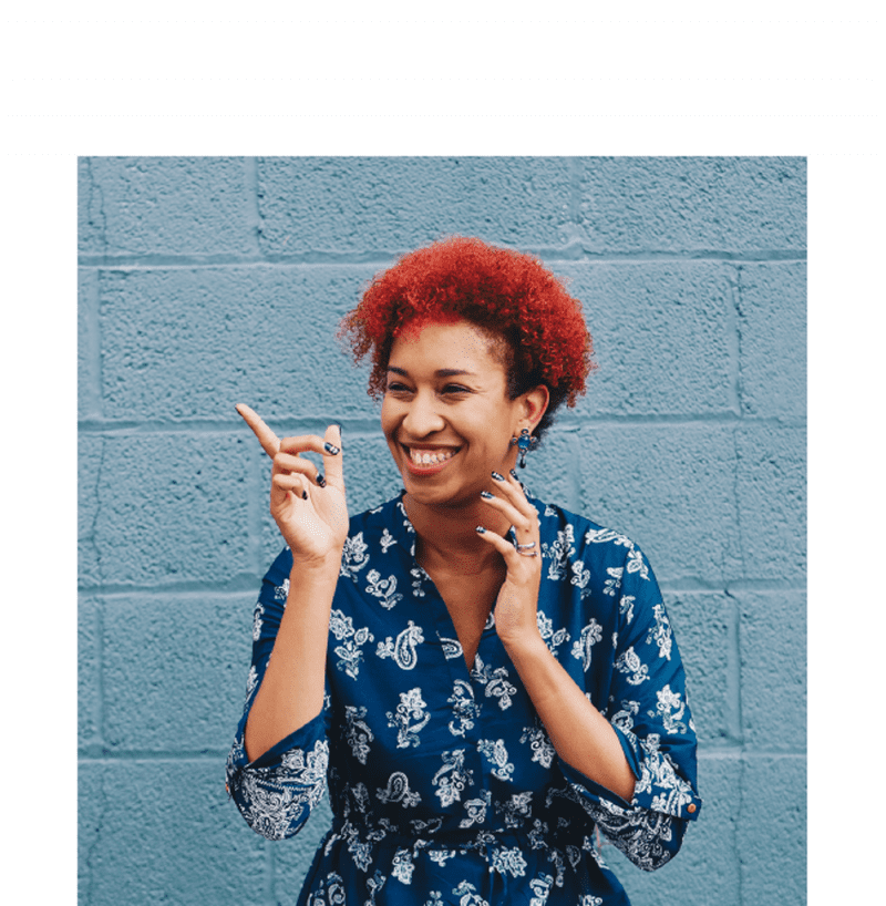 girl with red hair pointing and smiling
