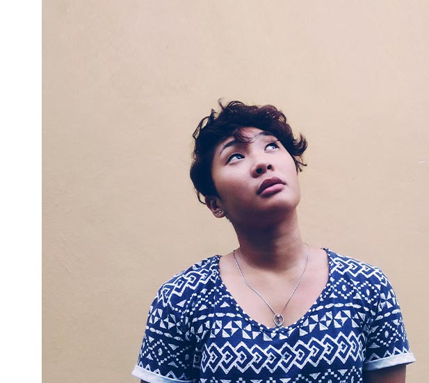 girl in blue shirt against tan background